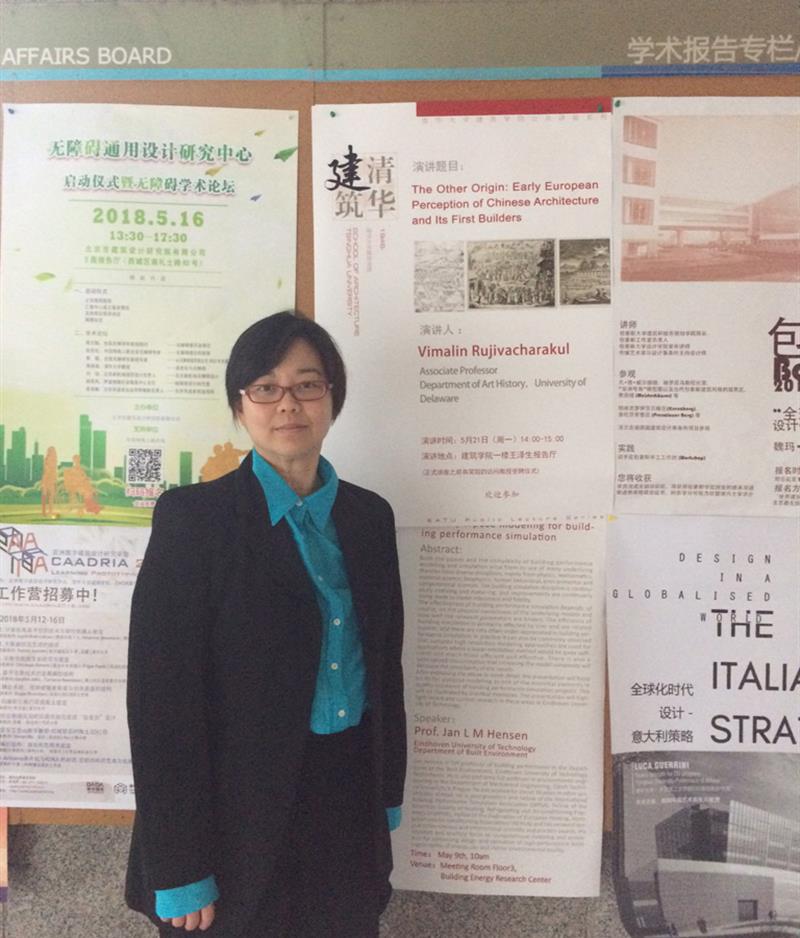 Prof. Rujivacharakul standing in front of some posters. 