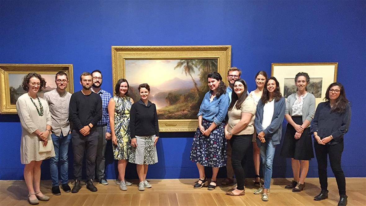 Professor Wendy Bellion, Dr. Anna Marley and graduate students stand in front of a landscape painting at PAFA