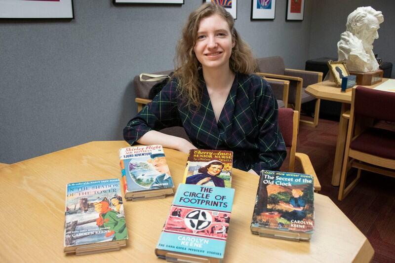 Miriam-Helene Rudd sits with a few books from her collection.